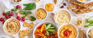 assortment of hummus and vegetables across a table